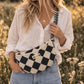 Handmade cross body bag Elara Wildflower Path in noir check worn by woman in a field.