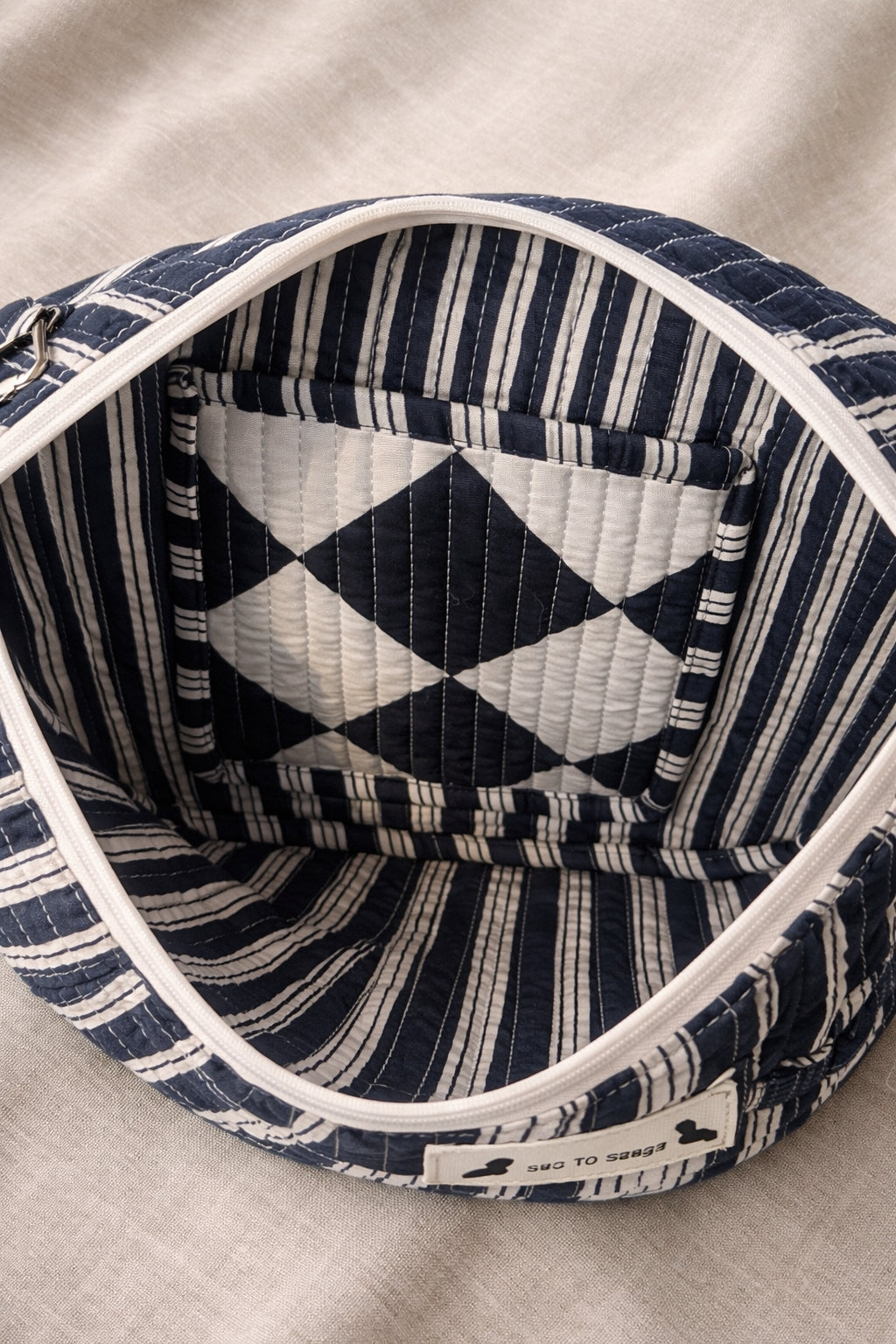 Handmade cross body bag Elara Wildflower Path in noir check worn by woman in a field.