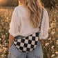 Handmade cross body bag Elara Wildflower Path in noir check worn by woman in a field.