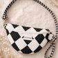 Handmade cross body bag Elara Wildflower Path in noir check worn by woman in a field.