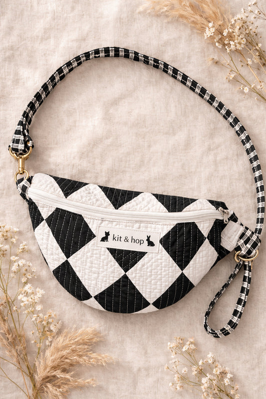 Handmade cross body bag Elara Wildflower Path in noir check worn by woman in a field.