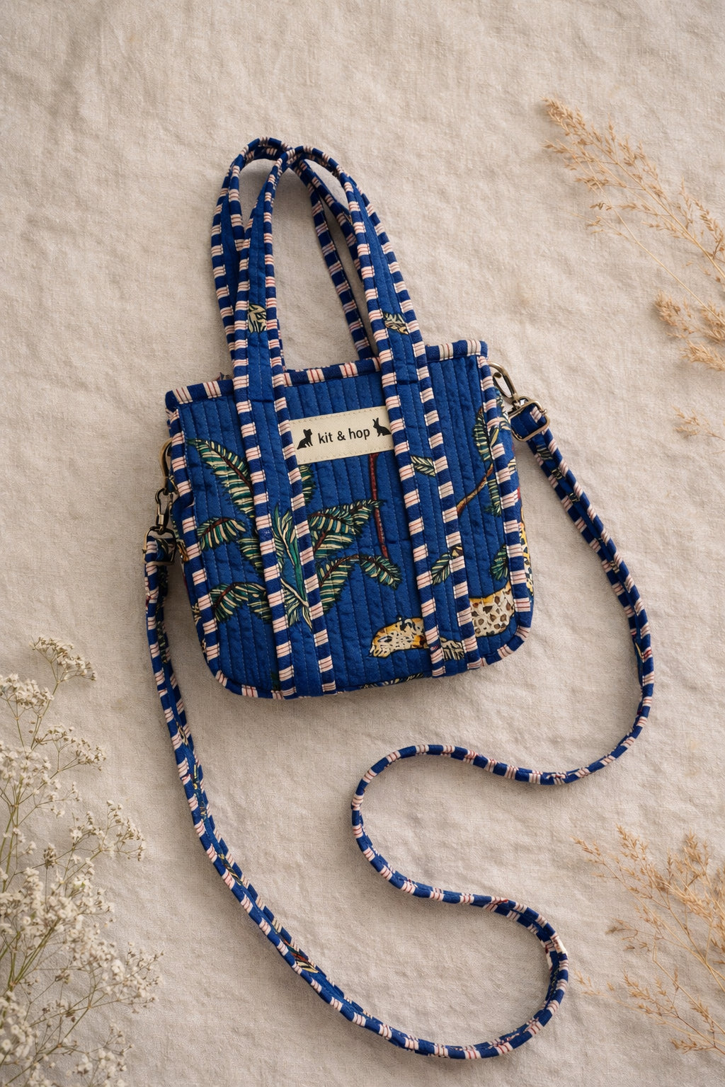 Handmade Cotton Mini Tote Bag - Lila - Wild Meadow - Indigo hanging on a wooden hook with decorative flowers.