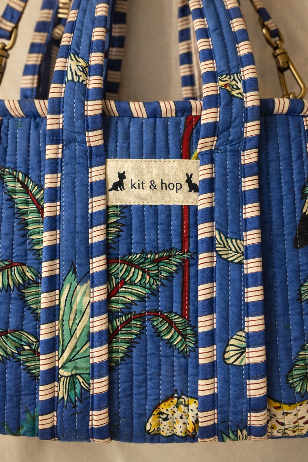 Handmade Cotton Mini Tote Bag - Lila - Wild Meadow - Indigo hanging on a wooden hook with decorative flowers.