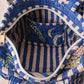 Handmade Cotton Mini Tote Bag - Lila - Wild Meadow - Indigo hanging on a wooden hook with decorative flowers.