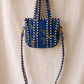 Handmade Cotton Mini Tote Bag - Lila - Wild Meadow - Indigo hanging on a wooden hook with decorative flowers.