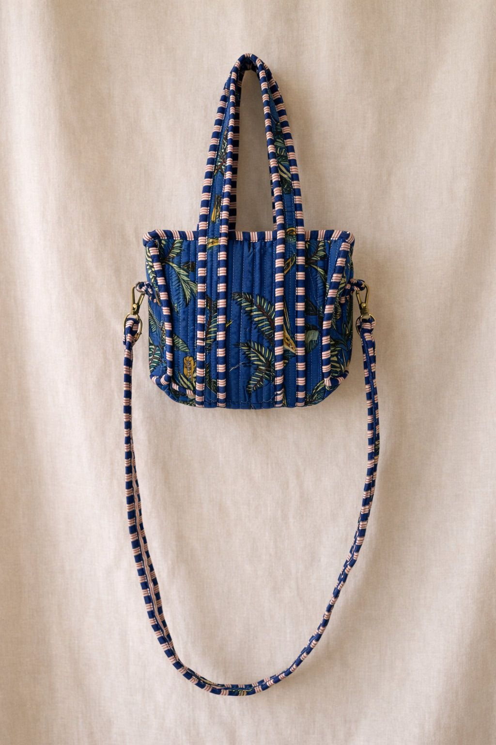 Handmade Cotton Mini Tote Bag - Lila - Wild Meadow - Indigo hanging on a wooden hook with decorative flowers.