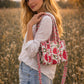 Handmade Cotton Mini Tote Bag - Lila - Wild Meadow - Arlo displayed on a wall with floral decor.