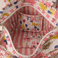 Handmade Cotton Mini Tote Bag - Lila - Wild Meadow - Arlo displayed on a wall with floral decor.