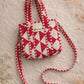 Handmade Cotton Mini Tote Bag with red and white diamond pattern, hanging on a wall, showcasing its stylish design.