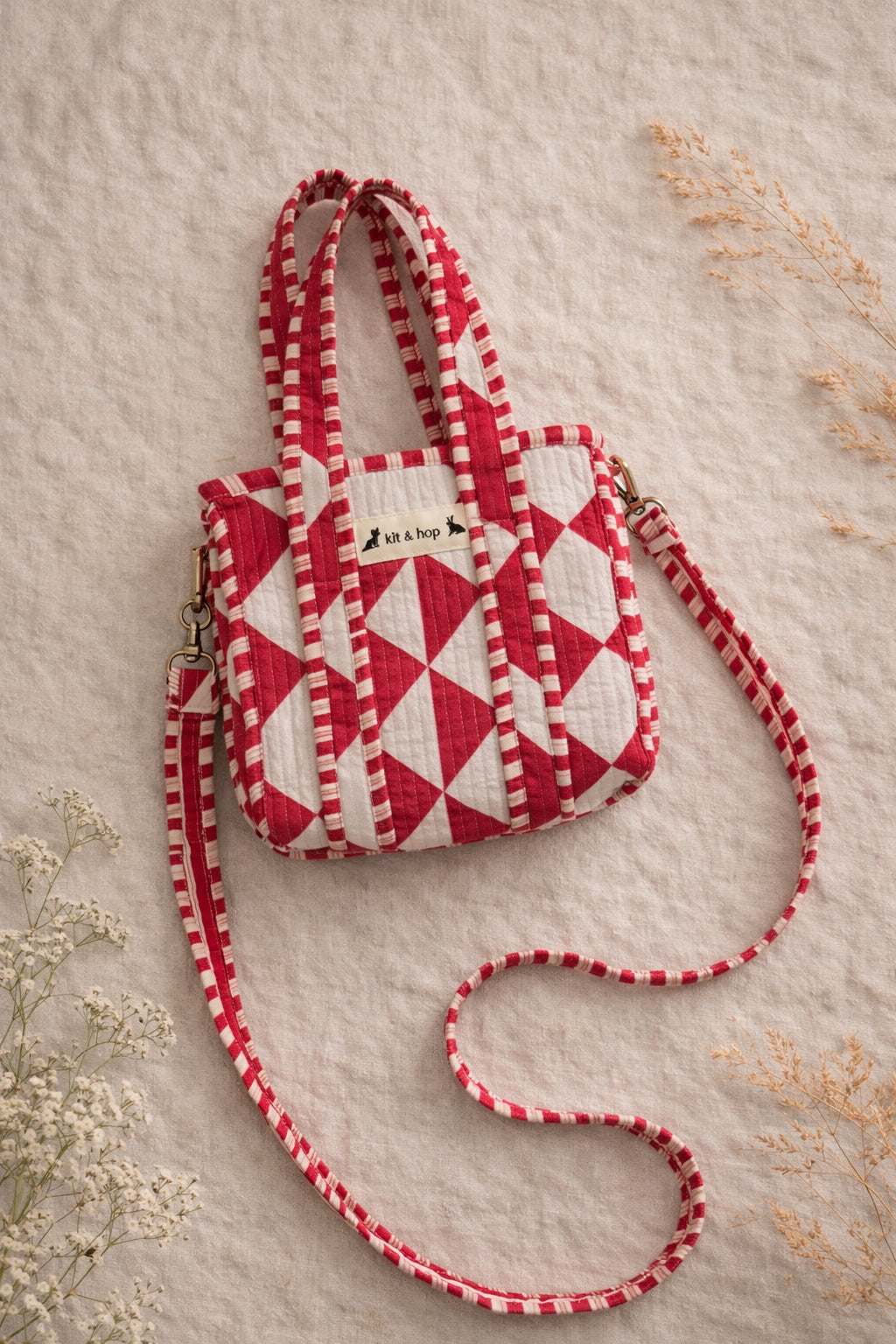 Handmade Cotton Mini Tote Bag with red and white diamond pattern, hanging on a wall, showcasing its stylish design.