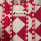 Handmade Cotton Mini Tote Bag with red and white diamond pattern, hanging on a wall, showcasing its stylish design.