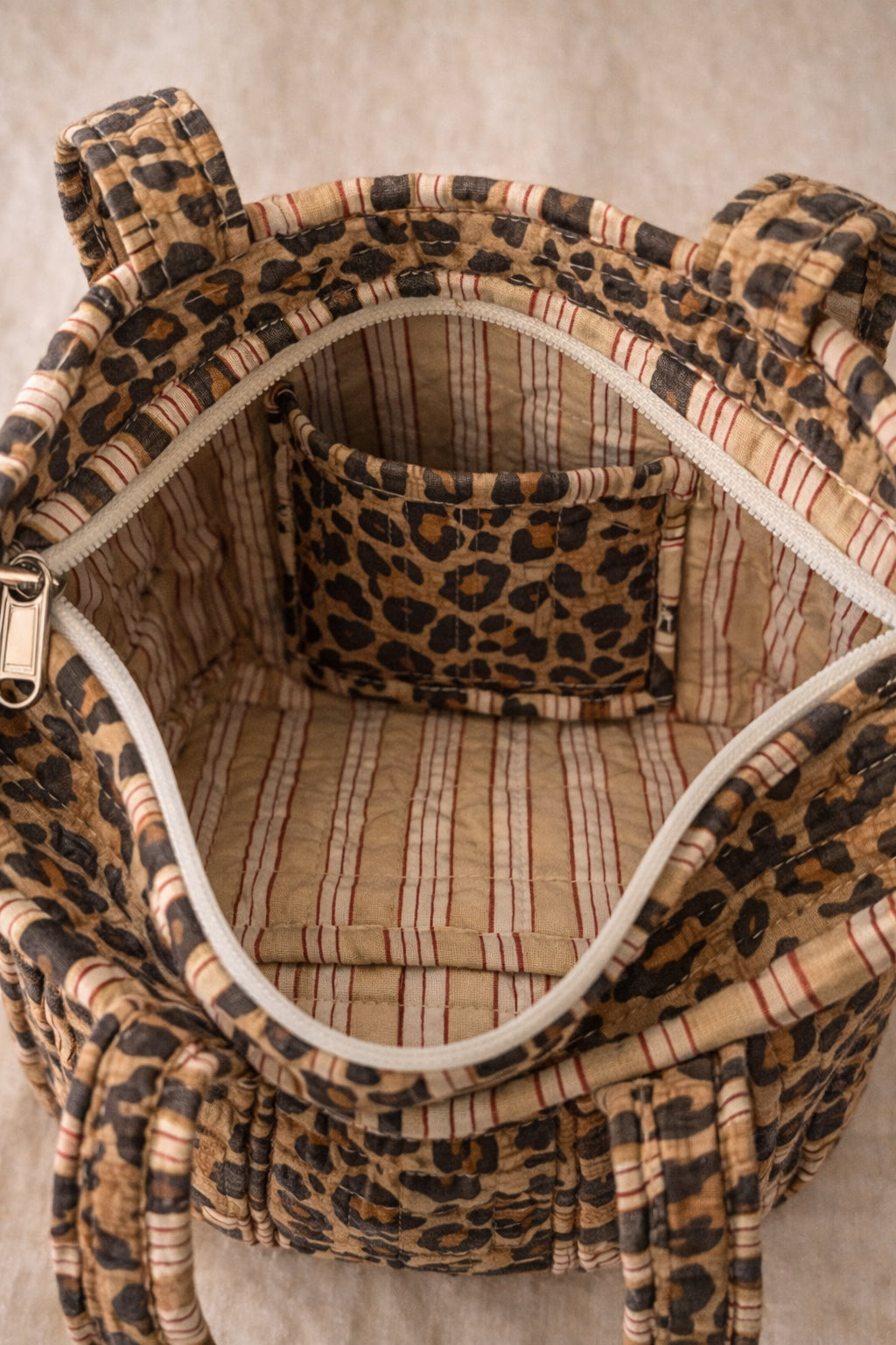 Handmade Cotton Mini Tote Bag - Lila - Wild Meadow -Sable with a stylish leopard print design, hung on a wooden hook.