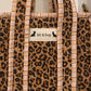 Handmade Cotton Mini Tote Bag - Lila - Wild Meadow -Sable with a stylish leopard print design, hung on a wooden hook.