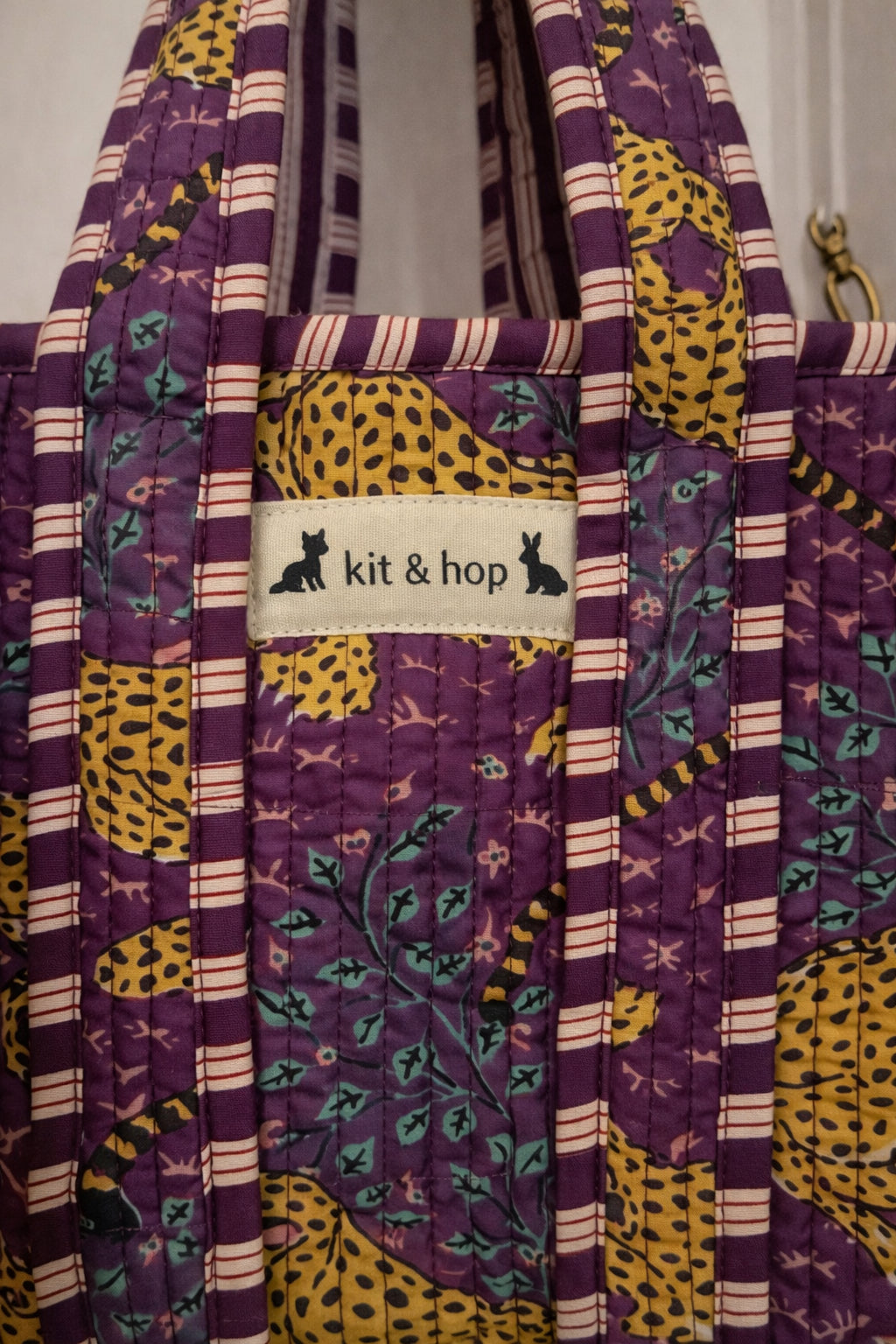 Handmade Cotton Mini Tote Bag in Wild Meadow Violet hanging on wall, perfect for everyday essentials.