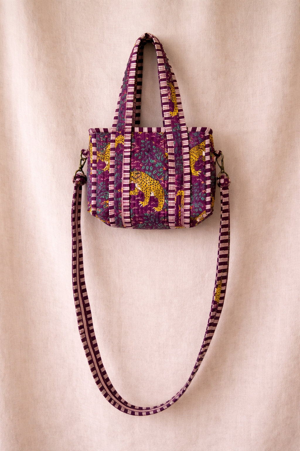 Handmade Cotton Mini Tote Bag in Wild Meadow Violet hanging on wall, perfect for everyday essentials.