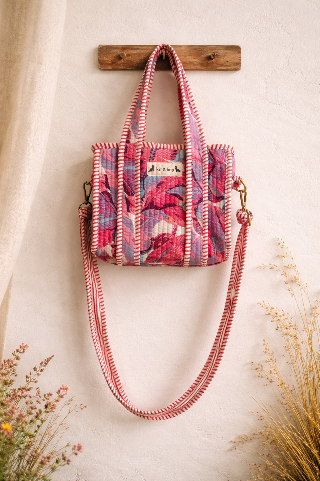 Handmade Cotton Mini Tote Bag - Lila - Wild Meadow - Paloma hanging against a wall with floral decorations.