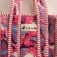 Handmade Cotton Mini Tote Bag - Lila - Wild Meadow - Paloma hanging against a wall with floral decorations.
