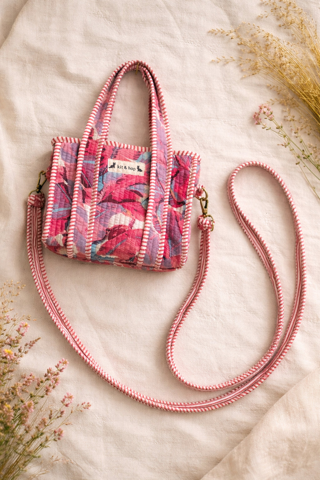 Handmade Cotton Mini Tote Bag - Lila - Wild Meadow - Paloma hanging against a wall with floral decorations.