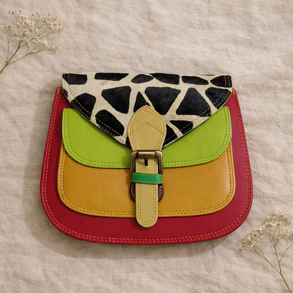 Handmade Leather Crossbody Bag in vibrant colors: green, yellow, red, and black and white print, showcasing unique design.