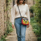 Handmade Leather Crossbody Bag in vibrant colors: green, yellow, red, and black and white print, showcasing unique design.
