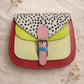 Handmade Leather Crossbody Bag - Romy in colorful leather with unique pattern and pink buckle, showcasing sustainable craftsmanship.