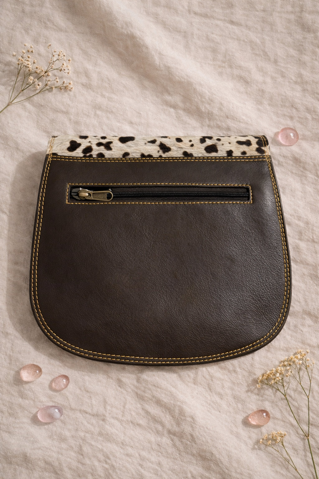 Handmade Leather Crossbody Bag featuring colorful patches of pink, blue, yellow, and a spotted flap on a soft background.