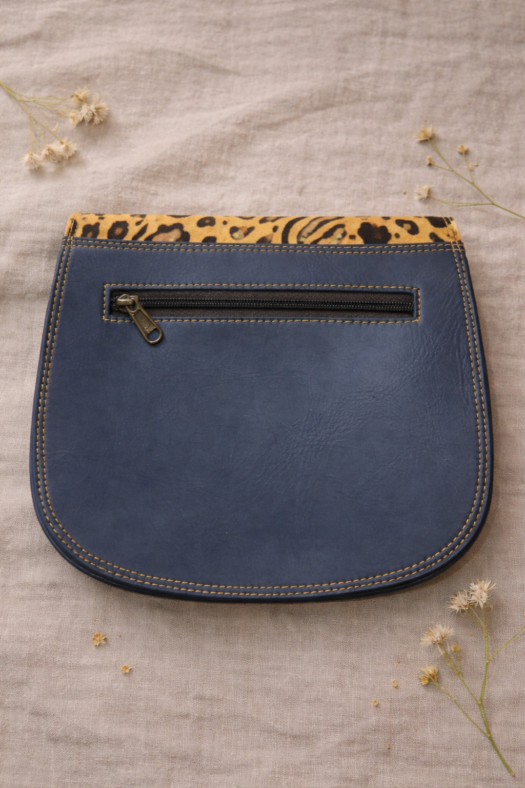 Handmade Leather Crossbody Bag - Romy in vibrant colors with leopard print flap, showcasing unique design and sustainability.