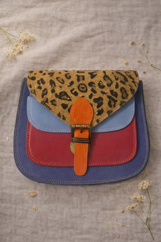 Handmade Leather Crossbody Bag - Romy in vibrant colors with leopard print flap, showcasing unique design and sustainability.