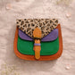 Handmade Leather Crossbody Bag in bright colors with a leopard print flap, displayed on a soft background.