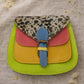 Handmade Leather Crossbody Bag featuring vibrant colors and a unique design with a spotted flap and buckle closure.