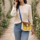 Handmade Leather Crossbody Bag - Romy - Walled Garden - Primrose displayed on soft fabric with flower petals around.