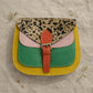 Handmade Leather Crossbody Bag - Romy with colorful panels and animal print flap on a light background.