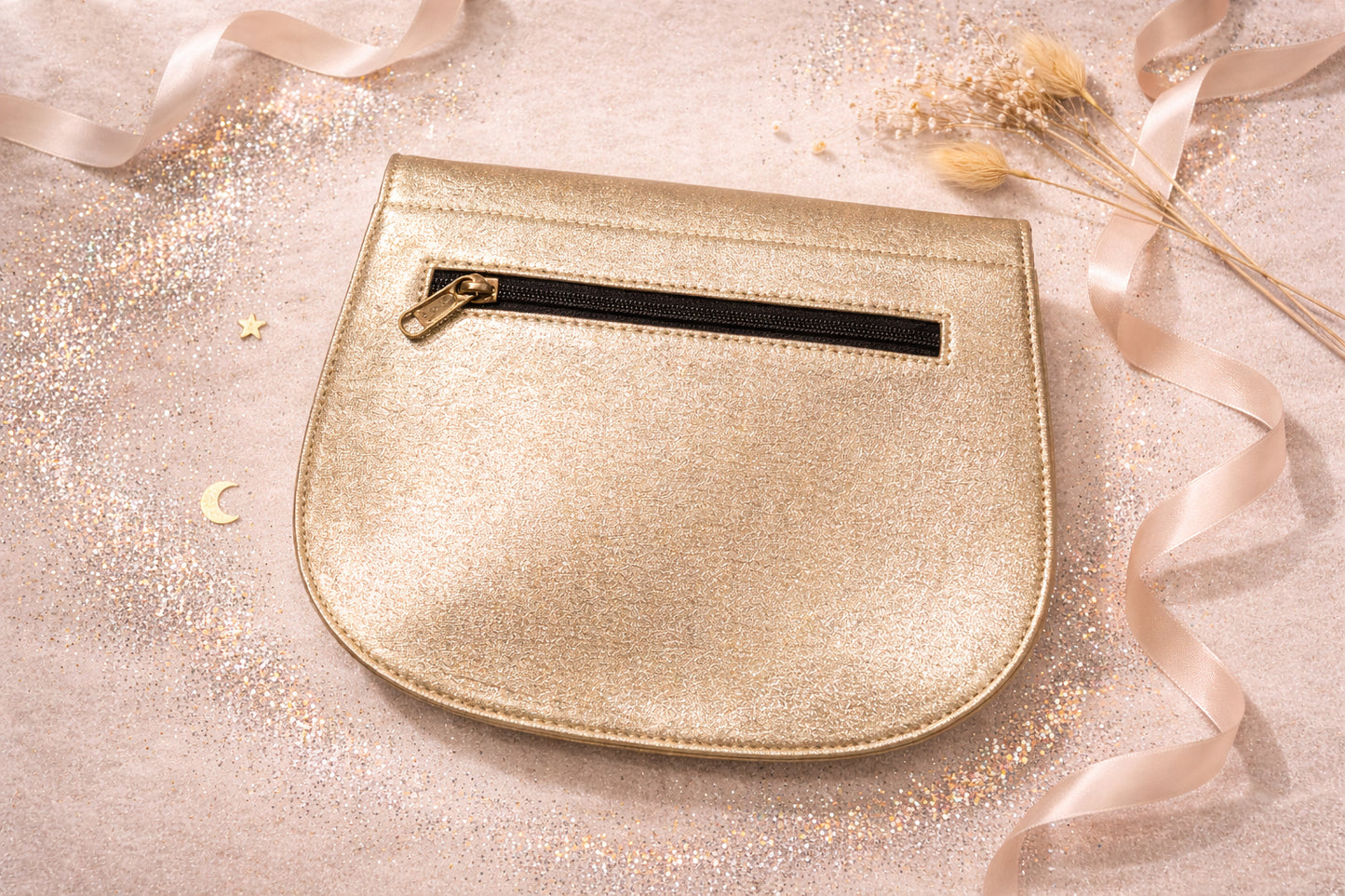 Handmade Leather Crossbody Bag - Romy - Aurelia in metallic gold finish on a sparkling background.