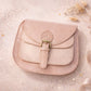 Handmade Leather Crossbody Bag - Romy - Petal resting on a sparkling surface with delicate flowers and ribbon.