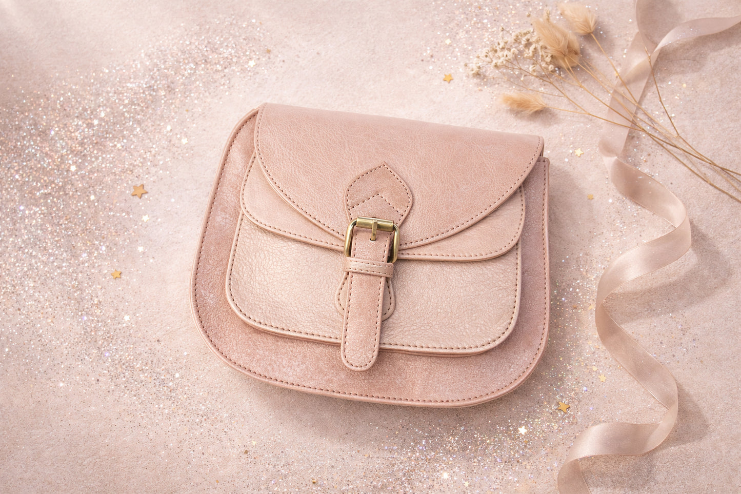 Handmade Leather Crossbody Bag - Romy - Petal resting on a sparkling surface with delicate flowers and ribbon.