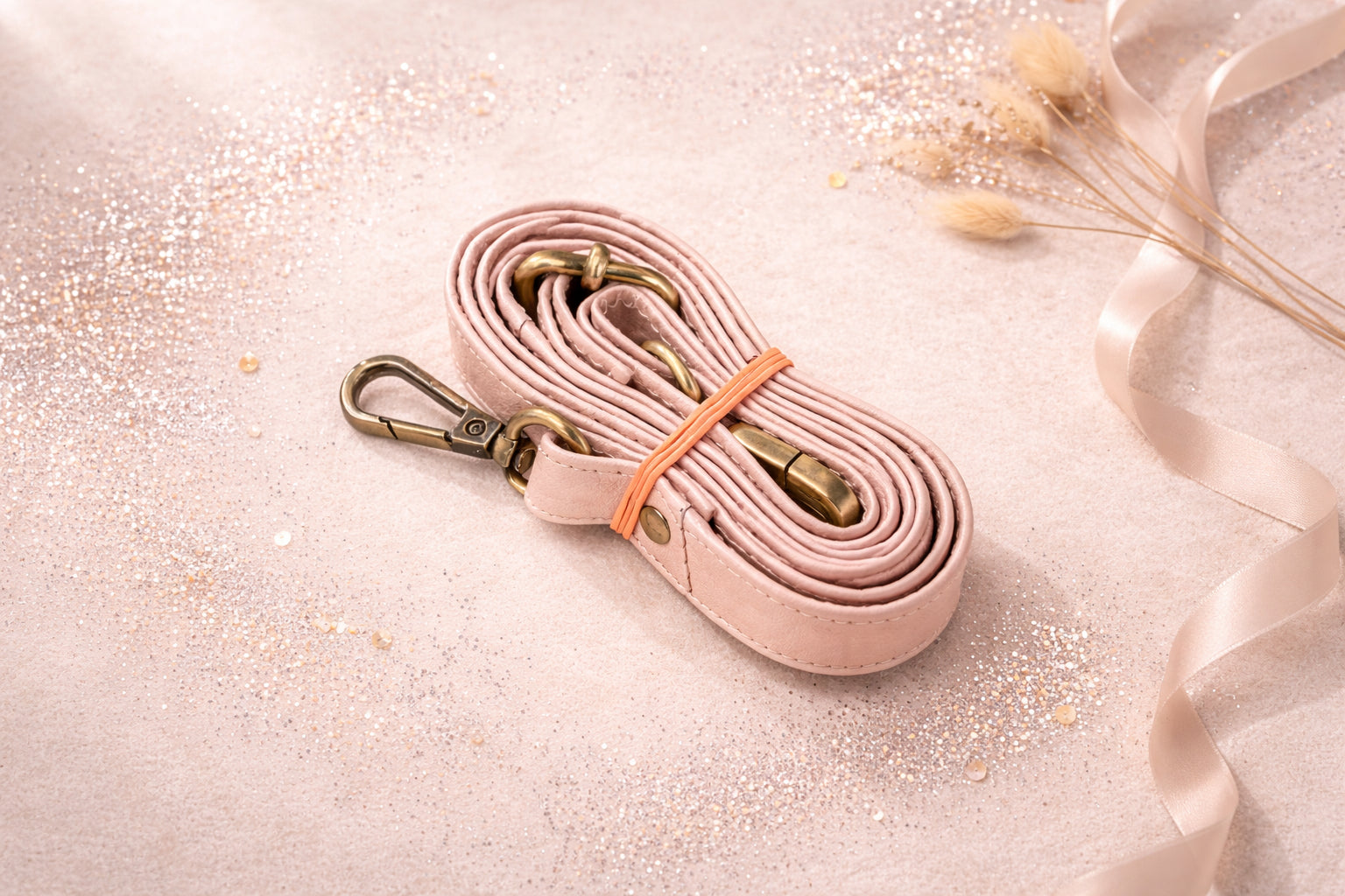 Handmade Leather Crossbody Bag - Romy - Petal resting on a sparkling surface with delicate flowers and ribbon.