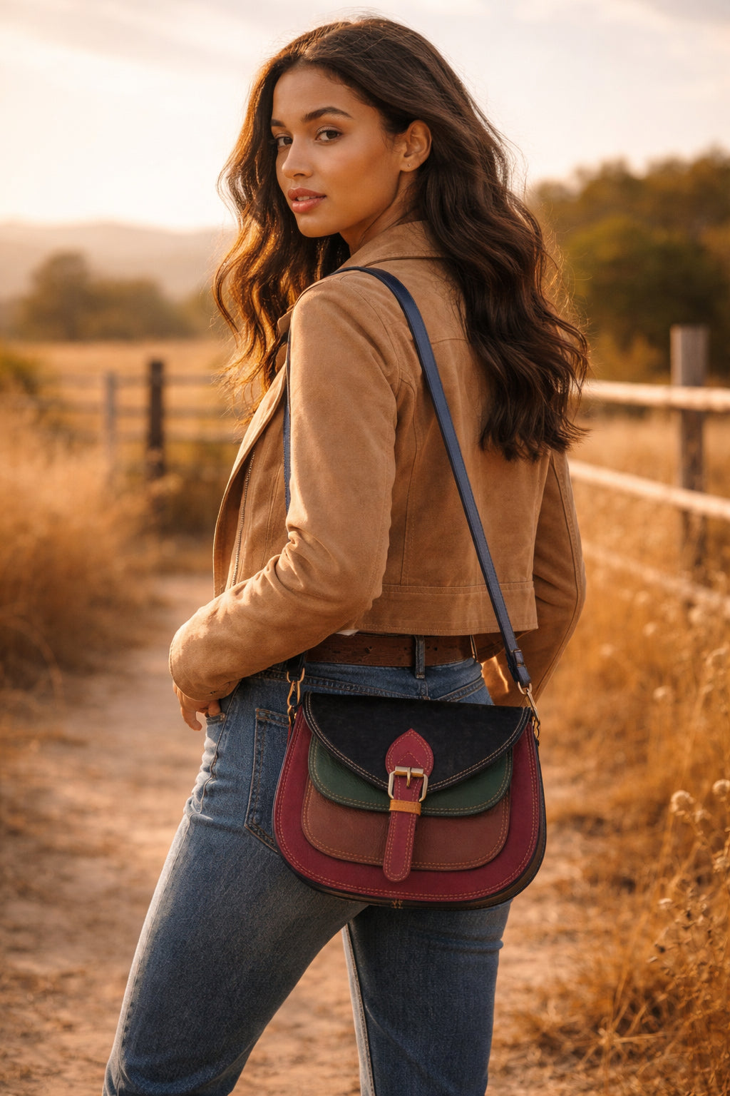 Handmade Leather Crossbody Bag - Romy featuring multiple colors and a stylish buckle strap on a textured background.