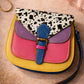 Handmade Leather Crossbody Bag featuring vibrant colors and a unique spotted design on the flap.